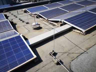 Photovoltaik und Fangstangen mit Kabelkanälen auf einem Flachdach.
